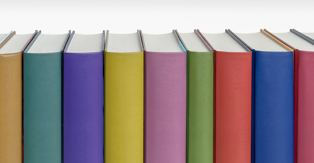 Multi-colored books on a shelf.